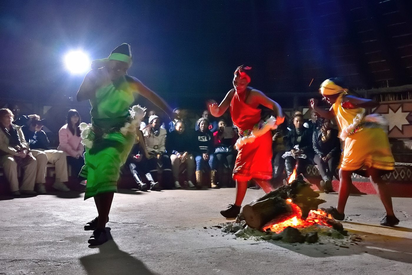 Dancers in traditional attire performing around a fire at Lesedi Cultural Village