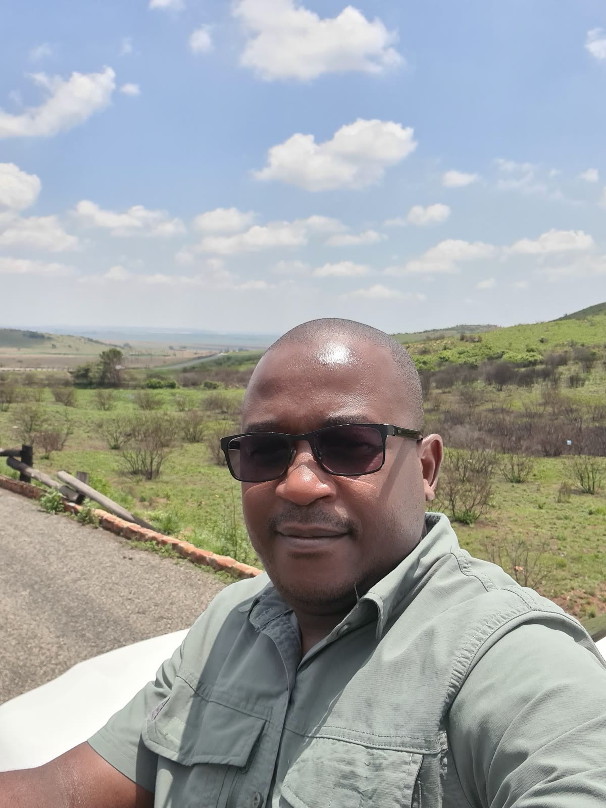 Sibusiso Dlamini, founder of Dlamini 4 Africa Tours & Safaris, in field uniform on a grassland reserve in South Africa